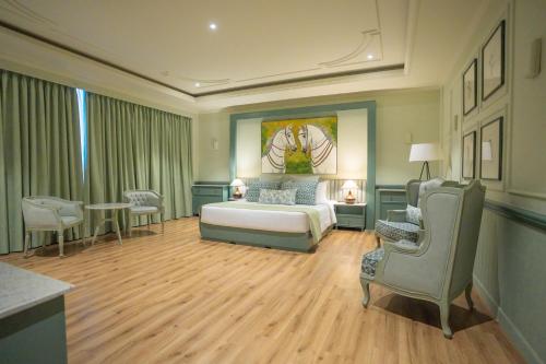 a bedroom with a bed and a table and chairs at Grandeeza Hotel by Galison in Negombo