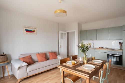 a living room with a couch and a table at L'écrin iodé - 200 m de la plage in Lancieux