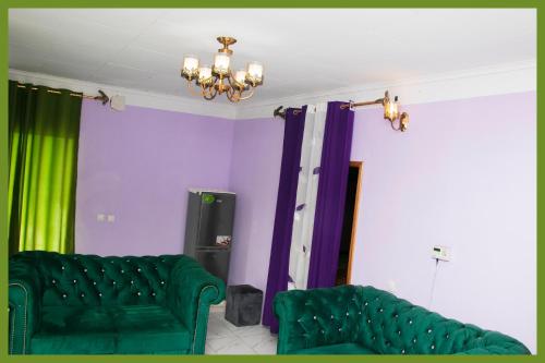 a living room with a green couch and purple and green curtains at Bafoussam derrière Stade municipal Bamendzi in Bafoussam