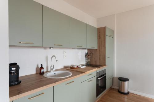 a kitchen with white cabinets and a sink at L'écrin iodé - 200 m de la plage in Lancieux