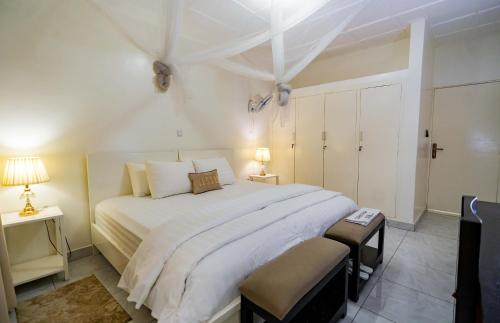 a bedroom with a large white bed and two lamps at Blue Veil Villa Hotel in Kigali
