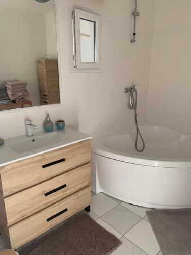 une salle de bain blanche avec une baignoire et un lavabo dans l'établissement A fleur d'eau, à Saint-Omer