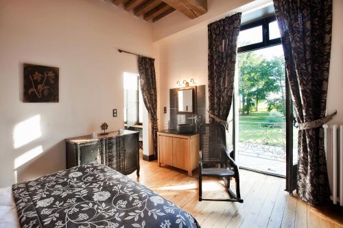 une chambre avec un lit, un bureau et une fenêtre dans l'établissement Château de Lans, à Lans