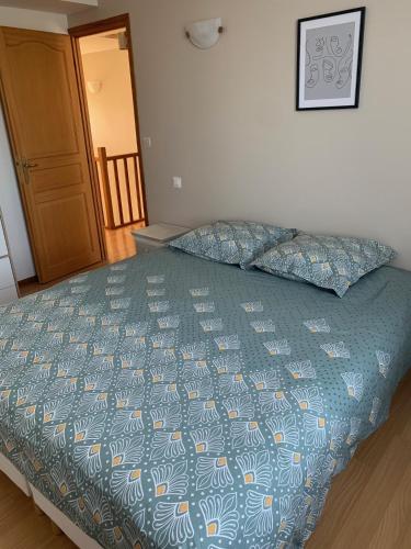 - un lit avec une couette bleue dans une chambre dans l'établissement A fleur d'eau, à Saint-Omer