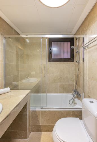 a bathroom with a shower and a toilet and a tub at Coto Real 2047 ANAFI in Manilva