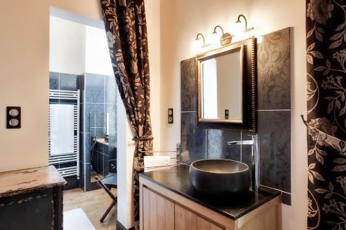 une salle de bain avec un lavabo et un miroir dans l'établissement Château de Lans, à Lans