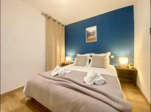 a bedroom with a large bed with towels on it at Le Point Virgule - Parking Privé - Clim in Montauban