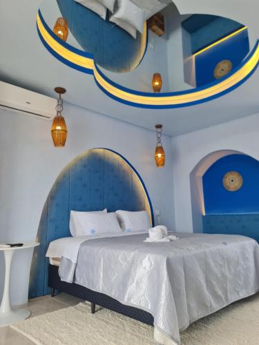 a blue bedroom with a bed and a mirror at Hotel Paraiso Maragogi LTDA in Maragogi