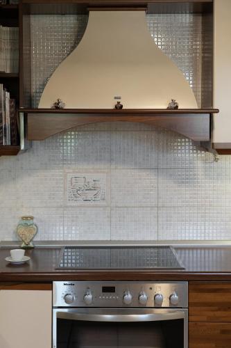 a kitchen with a stove and a white tiled wall at Amara Haven in Aígio