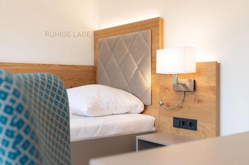 a small room with a bed and a lamp at Hotel Ross in Meißen