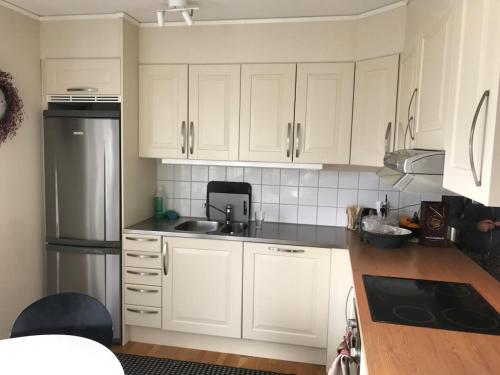 a kitchen with white cabinets and a sink and a refrigerator at Perfect location ski-in Åre in Åre