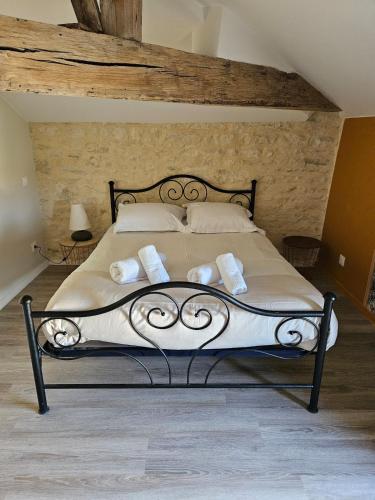 une chambre avec un lit avec des draps blancs et des oreillers dans l'établissement maison de bourg au calme, proche du Futuroscope, à Yversay