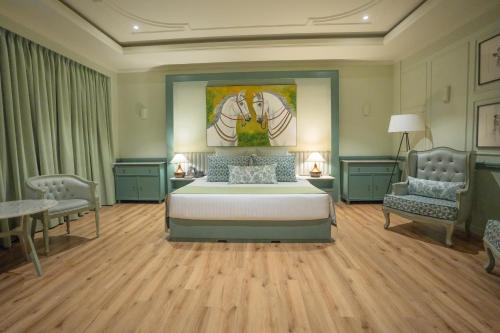 a large bedroom with a bed and two chairs at Grandeeza Hotel by Galison in Negombo