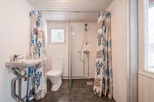 a bathroom with a toilet and a sink and a shower at House in Beautiful Nature by the Sea Bay with Sauna & BBQ in Salpar