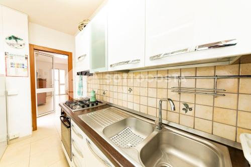 eine Küche mit Spüle und Herd oberen Backofen in der Unterkunft Villa con piscina Maracuja - Torre Dell'Orso in Torre dell'Orso