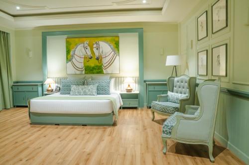 a bedroom with a bed and a painting of two horses at Grandeeza Hotel by Galison in Negombo