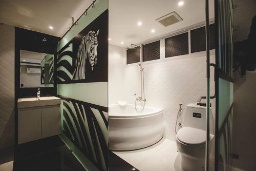 a bathroom with a tub and a toilet and a sink at Double Five in Bangkok