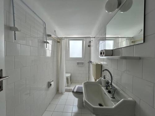 biała łazienka z umywalką i toaletą w obiekcie Tinion Urban Hotel w mieście Tinos