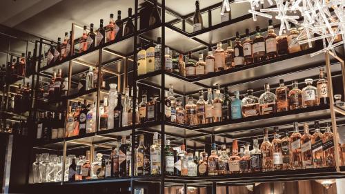 a wall of bottles of alcohol on shelves in a bar at Bellman Hotel in Berlin