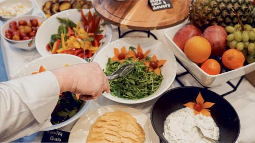 a person holding a fork in a bowl of food at Bellman Hotel in Berlin