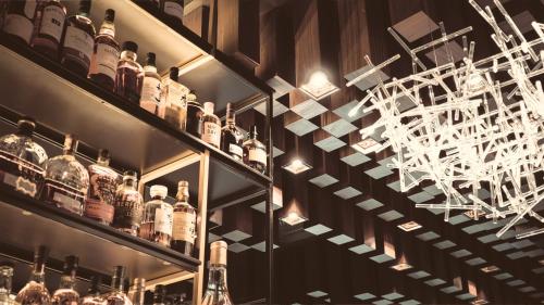 a shelf with bottles of alcohol and a chandelier at Bellman Hotel in Berlin