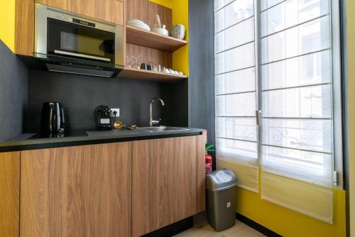 une cuisine avec un évier et un micro-ondes dans l'établissement Scandinavian Urban 2 - 2BR apartment in center close to Palais des Festivals and the beach, à Cannes