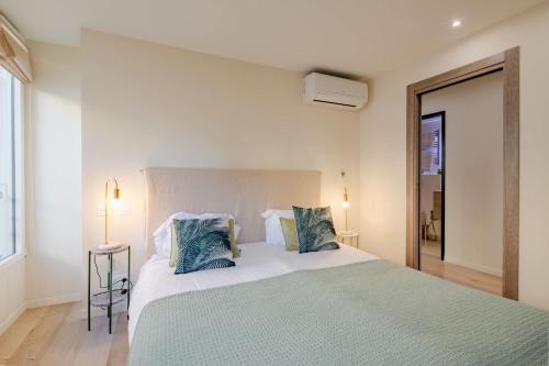 une chambre avec un grand lit avec des oreillers bleus dans l'établissement Scandinavian Urban 3 - 2BR apartment in Cannes center - close to the beach and Palais, à Cannes