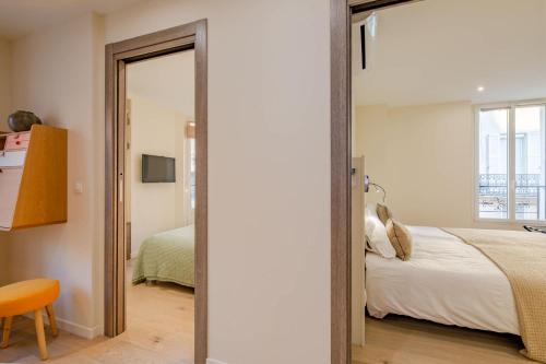 une chambre avec un lit et un miroir dans l'établissement Scandinavian Urban 3 - 2BR apartment in Cannes center - close to the beach and Palais, à Cannes