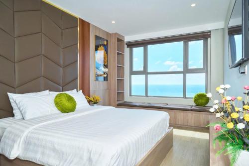 a bedroom with a large white bed and a window at T-Plantino - Căn hộ Codotel The Sóng 5 Sao - Free swimmingpool, Gym, Sauna in Vung Tau