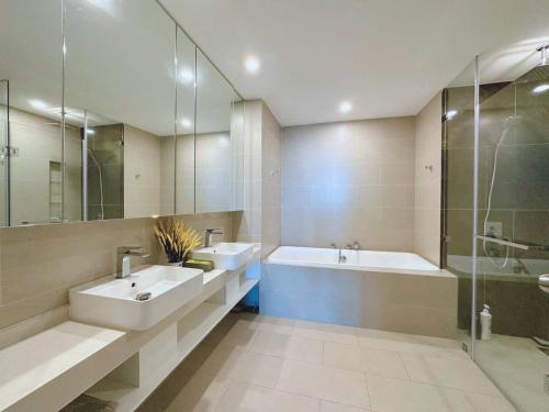 a bathroom with two sinks and a tub and a shower at T-Plantino - Căn hộ Codotel The Sóng 5 Sao - Free swimmingpool, Gym, Sauna in Vung Tau