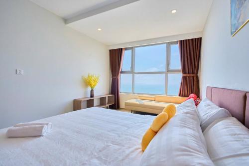 a bedroom with a large bed with a large window at T-Plantino - Căn hộ Codotel The Sóng 5 Sao - Free swimmingpool, Gym, Sauna in Vung Tau