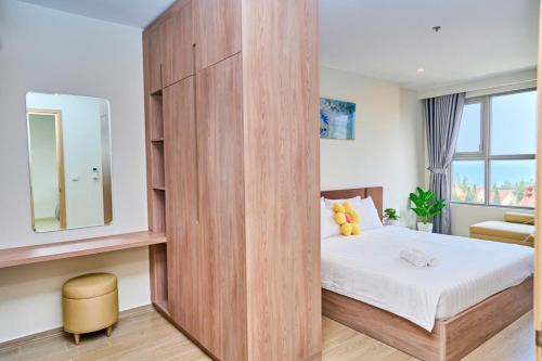 a bedroom with a large wooden partition with a bed at T-Plantino - Căn hộ Codotel The Sóng 5 Sao - Free swimmingpool, Gym, Sauna in Vung Tau