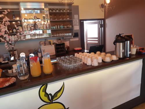 a bar with glasses of orange juice on a counter at Toscca in Čelákovice