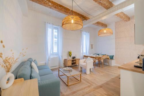 un salon avec un canapé bleu et une table dans l'établissement Terra Nova - Appt climatisé au coeur de Marseille, à Marseille