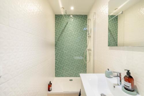 La salle de bains est pourvue d'une douche et d'un lavabo blanc. dans l'établissement Terra Nova - Appt climatisé au coeur de Marseille, à Marseille