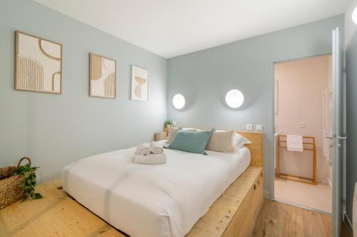 une chambre avec un grand lit avec des draps blancs dans l'établissement Terra Nova - Appt climatisé au coeur de Marseille, à Marseille