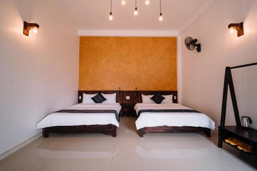 two beds in a room with white walls at Ethnic JR in Dồng Văn