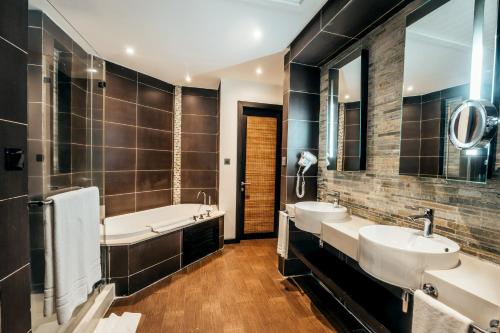 a bathroom with two sinks and a tub at Crystals Beach Resort Belle Mare, a member of Radisson Individuals in Belle Mare