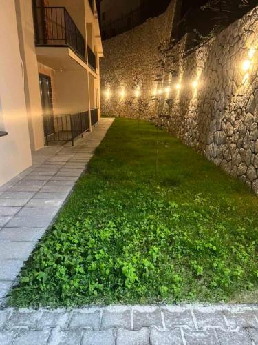 a courtyard of a building with a green lawn with lights at D & O Apartments in Mavrovo