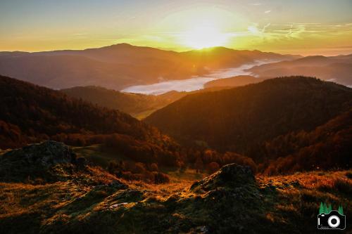 a view of a mountain valley with the sun setting at L Authentique Vosgien in Vecoux