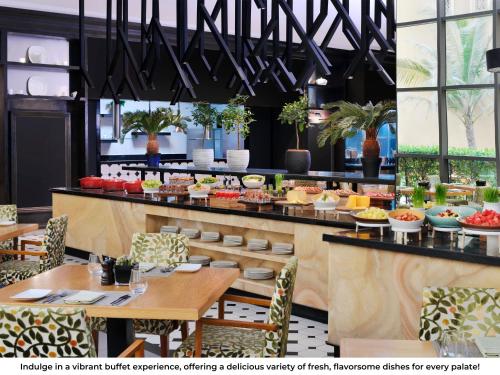 a restaurant with tables and chairs and a buffet at Mövenpick Hotel Jumeirah Beach in Dubai