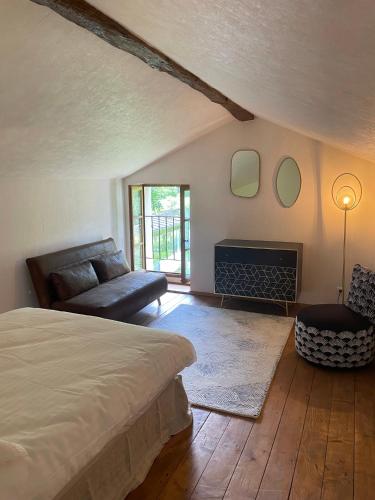 une chambre avec un lit, un canapé et une cheminée dans l'établissement Maison de charme dans un cadre d'exception, 8 pers, à Saint-Romain