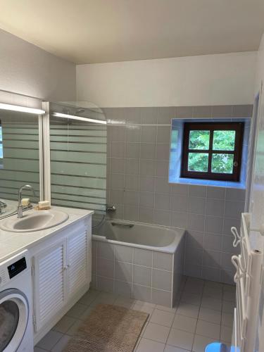 La salle de bains est pourvue d'une baignoire, d'un lavabo et d'un lave-linge. dans l'établissement Maison de charme dans un cadre d'exception, 8 pers, à Saint-Romain