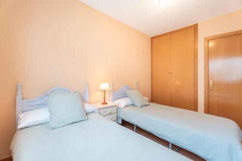 two twin beds in a room with a closet at Apartamento En Canet in Canet de Berenguer