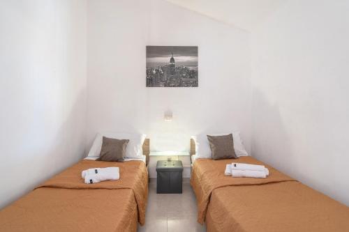 サンタ・マリア・デル・フォカッロにあるVilla Gardenia fronte mareの壁に絵が描かれた部屋のベッド2台