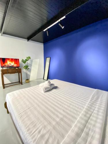 a bedroom with a white bed in a blue wall at Bayu Bayu Hotel by Soft Loft in Tanjung Bungah