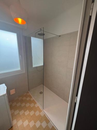 une douche avec une porte vitrée dans une salle de bain dans l'établissement Cyrille Besset - Charmant T2 avec balcon, à Cagnes-sur-Mer