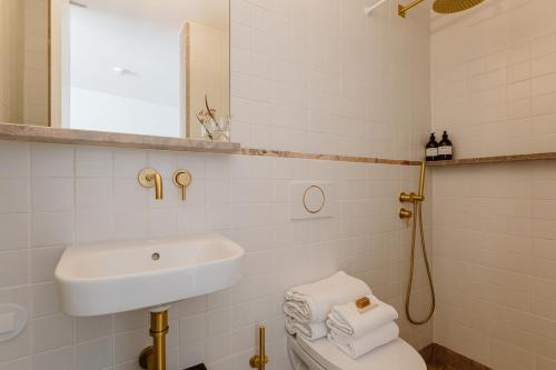 a white bathroom with a sink and a toilet at THE MODERNIST, Architecture experience in Faro