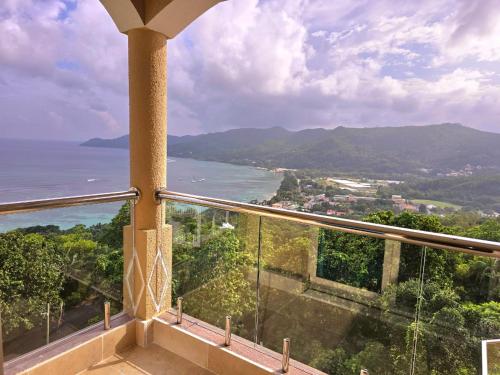 a balcony with a view of the ocean and mountains at Ocean Pearl Villa in Anse Royale