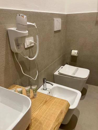 a bathroom with a white sink and a toilet at Palazzo Kapece in Monopoli